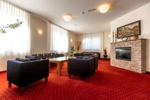 a conference room with a table and chairs and a fireplace at Hotel Bau Maribor in Maribor