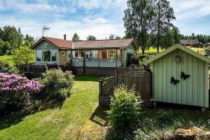 una pequeña casa verde con una valla en un patio en Two small Guest houses by lake rent out as One en Hjo