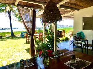 a dining room with a table and a view of the ocean at Corto Novo Maison d'hôtes-Camping in Nosy Be