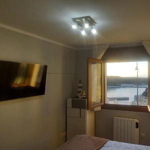 a bedroom with a bed and a large window at LUARCAPLAYA APARTAMENTO Plazas de garaje incluidas in Luarca