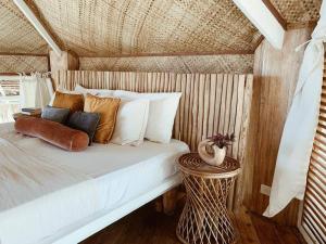 uma cama com muitas almofadas num quarto em Punta Punta Surf Retreat em General Luna