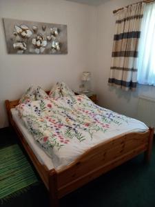 a bed with a floral comforter on it in a bedroom at Haus Auebach in Ellmau