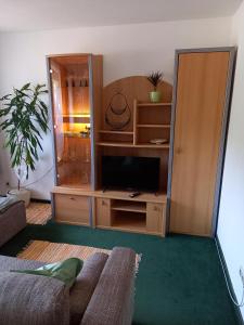 una sala de estar con un centro de entretenimiento con TV en Haus Auebach en Ellmau