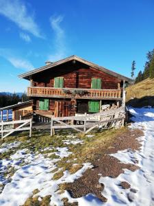 una cabaña de madera con nieve delante en Haus Auebach en Ellmau