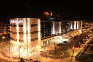 un edificio di notte con auto parcheggiate in un parcheggio di Gran Hotel Lakua a Vitoria-Gasteiz