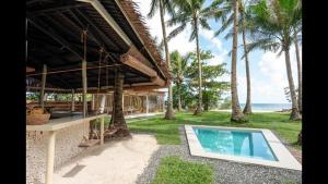 a house with a swimming pool next to the ocean at Punta Punta Surf Retreat in General Luna