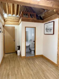 a bathroom with a toilet in a room with wooden ceilings at Gyodong Gaon in Jeonju