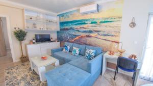 a living room with a blue couch and a painting of the ocean at Luka-Mostar Free Parking in Mostar