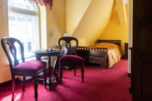 グダニスクにあるドム シュマノフのベッドルーム1室(ベッド1台、椅子2脚、テーブル付)