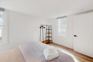 - une chambre blanche avec un lit et des serviettes dans l'établissement The Grey Lady, à Provincetown