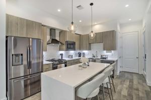 a kitchen with stainless steel appliances and a white counter top at Newly-Built Luxury Galleria Area Townhome! in Houston