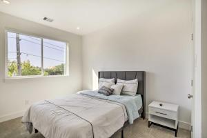 a white bedroom with a bed with a window at Newly-Built Luxury Galleria Area Townhome! in Houston