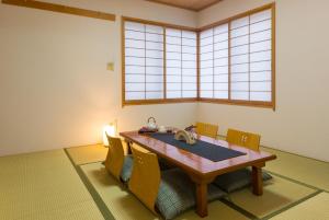 uma sala de jantar com mesa e cadeiras em スイートヴィラパノーラ八ヶ岳 em Kunizakai