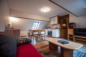 Habitación con cocina y sala de estar con mesa. en Apartments Jože Pekovec, en Bohinj