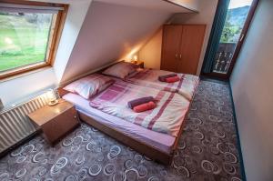 1 dormitorio con 1 cama con 2 almohadas rojas en Apartments Jože Pekovec, en Bohinj