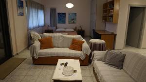 een woonkamer met 2 banken en een bed bij Romanos Patras studio in Romanós