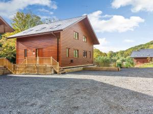 eine große Holzhütte mit einer Veranda und einer Auffahrt in der Unterkunft Waterside Lodge Five -uk38263 in Southowram