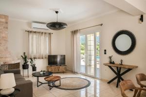 uma sala de estar com um sofá e uma televisão em Villa Thalassa Kefaloniaprivatevillas em Trapezaki