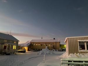 a group of buildings with snow on the ground at Kuttainen Lodge in Karesuando