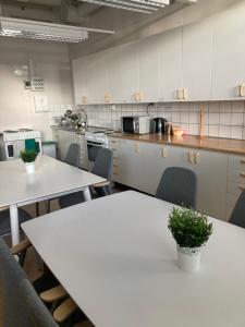 a kitchen with white tables and chairs in it at Kuttainen Lodge in Karesuando