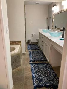 a bathroom with two sinks and a tub and a mirror at Large Southern Home with Swimming Pool, 5 king bed in Memphis