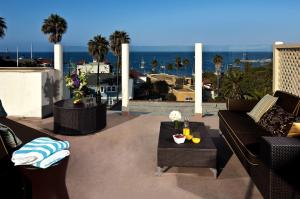 a patio with couches and a table with a view of the ocean at Aurora Hotel in Avalon