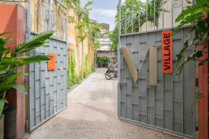 an alleyway between buildings with a gate with the letter m on it at M Village Lý Chính Thắng in Ho Chi Minh City