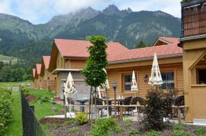 a house with a table and chairs in front of it at Feriendorf am Hahnenkamm in Reutte