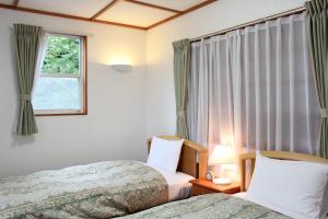 忍野村的住宿－スイートヴィラ山中湖，一间卧室设有两张床和窗户。