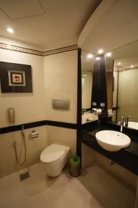 a bathroom with a toilet and a sink at SP Grand Days in Trivandrum