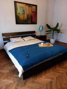 a bed with a blue blanket and a tray on it at First Station 26-11 in Krakow