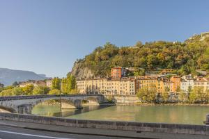 un pont sur une rivière en face d'une ville dans l'établissement R'Apparts Studio Chic des Quais, à Grenoble