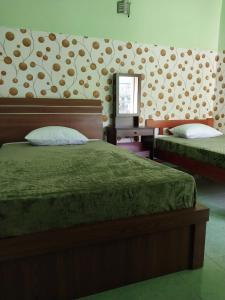 a bedroom with two beds and a mirror in it at Omah 365 Homestay in Sentool
