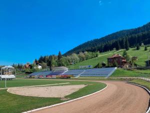 un estadio con un camino de tierra delante de él en Vila Stadion en Câmpulung Moldovenesc