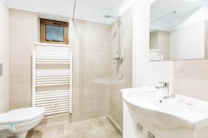 a white bathroom with a sink and a toilet at Vila Stadion in Câmpulung Moldovenesc