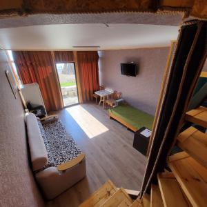 einen Blick über ein Zimmer mit einem Bett und einem TV in der Unterkunft Дом с видом на море на Белом пляже in Novy Afon
