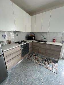 eine Küche mit weißen Schränken und Fliesenboden in der Unterkunft A casa di Milly in Triggiano