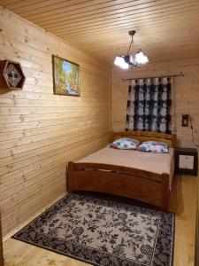 a bedroom with a bed in a wooden room at Котедж "Затишний відпочинок" in Huklyvyy