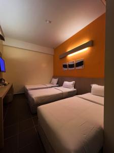 a hotel room with two beds and a tv at Fomecs Boutique Hotel, Jonker Street in Malacca