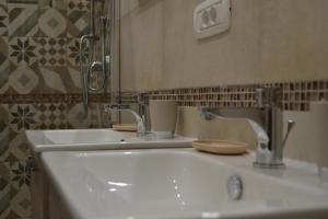 un bagno con due lavandini e due rubinetti di Karina's Rooms a Taranto