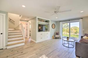 a living room with a staircase and a tv at Sunny Stockton Springs Home Less Than 1 Mi to Beach! in Stockton Springs