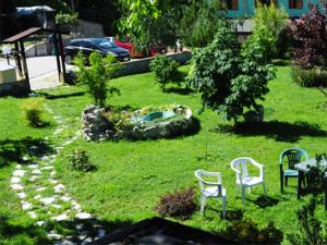 a garden with two chairs and a statue in the grass at Country House Al Faraone in Poggio Picenze
