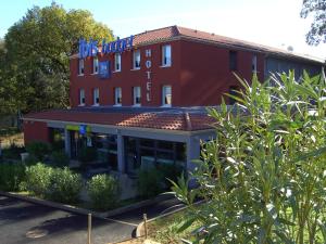 un bâtiment rouge avec un panneau en haut dans l'établissement ibis budget Brignoles Provence, à Brignoles