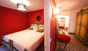 czerwona sypialnia z łóżkiem i czerwoną ścianą w obiekcie The Apartment Genova w Genui