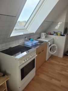 a kitchen with a stove and a sink and a window at Messe Zimmer Düsseldorf Airport in Düsseldorf