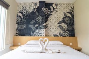 una camera da letto con due cigni seduti su un letto di Miko Rooms & Capsules hotel a Bungurasih