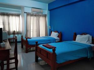 2 camas en una habitación con paredes azules en Kasarin Court, en Fang