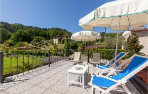 a patio with chairs and a table and an umbrella at 3 Bedroom Lovely Home In Camaiore in Camaiore