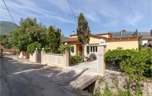a yellow house with a fence on a street at 3 Bedroom Lovely Home In Camaiore in Camaiore