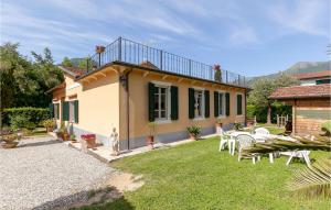 a house with a yard with chairs and a building at 3 Bedroom Lovely Home In Camaiore in Camaiore +28 photos